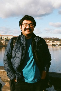 photo of student on bridge against a blue sky